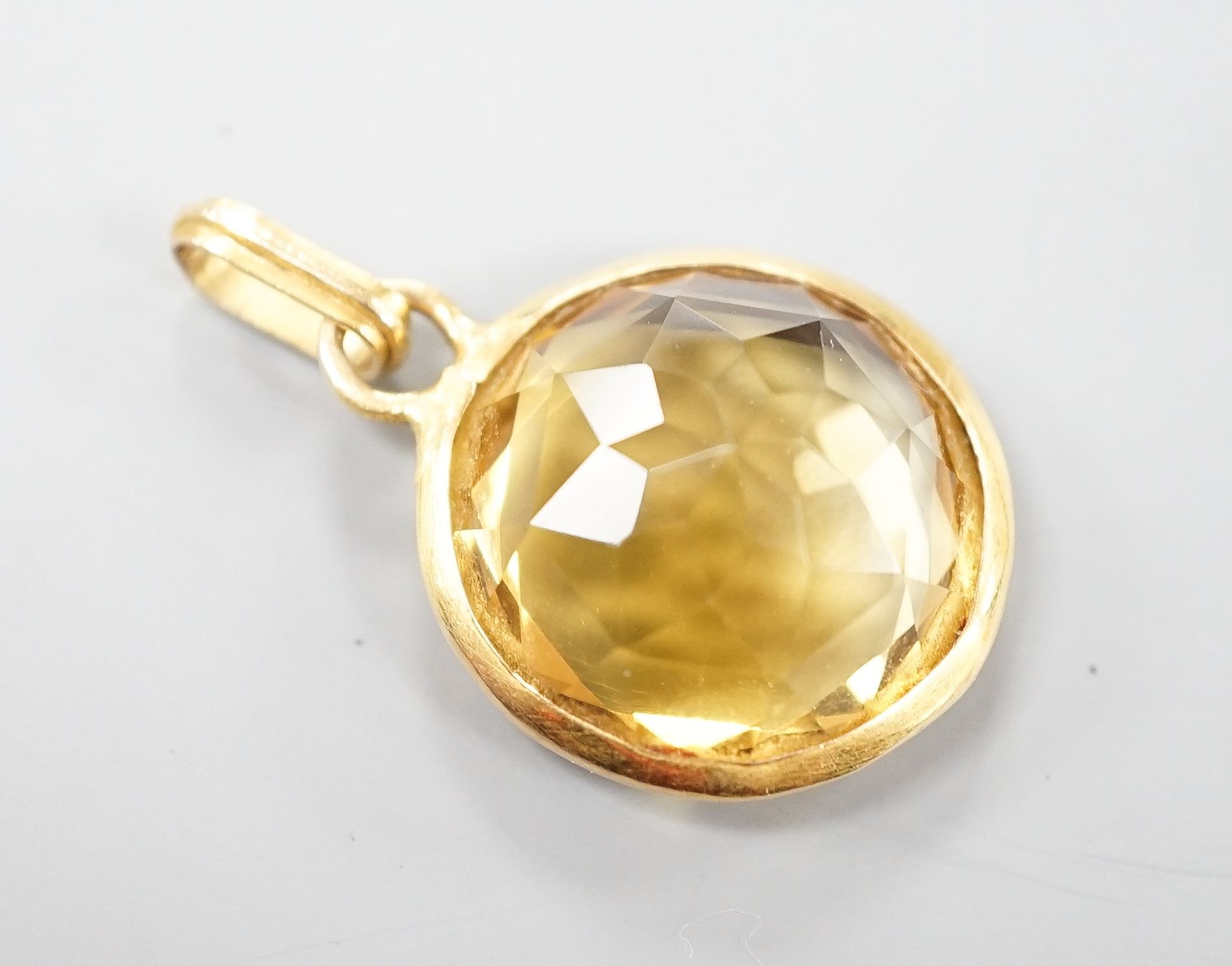 A yellow metal mounted facetted citrine set pendant, gross, 4.9 grams and a costume dress ring.